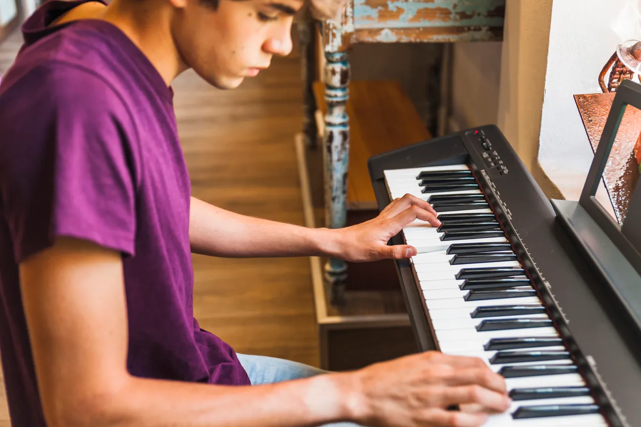 Adolescente al piano Adolescente practicando piano en una sesión relajada